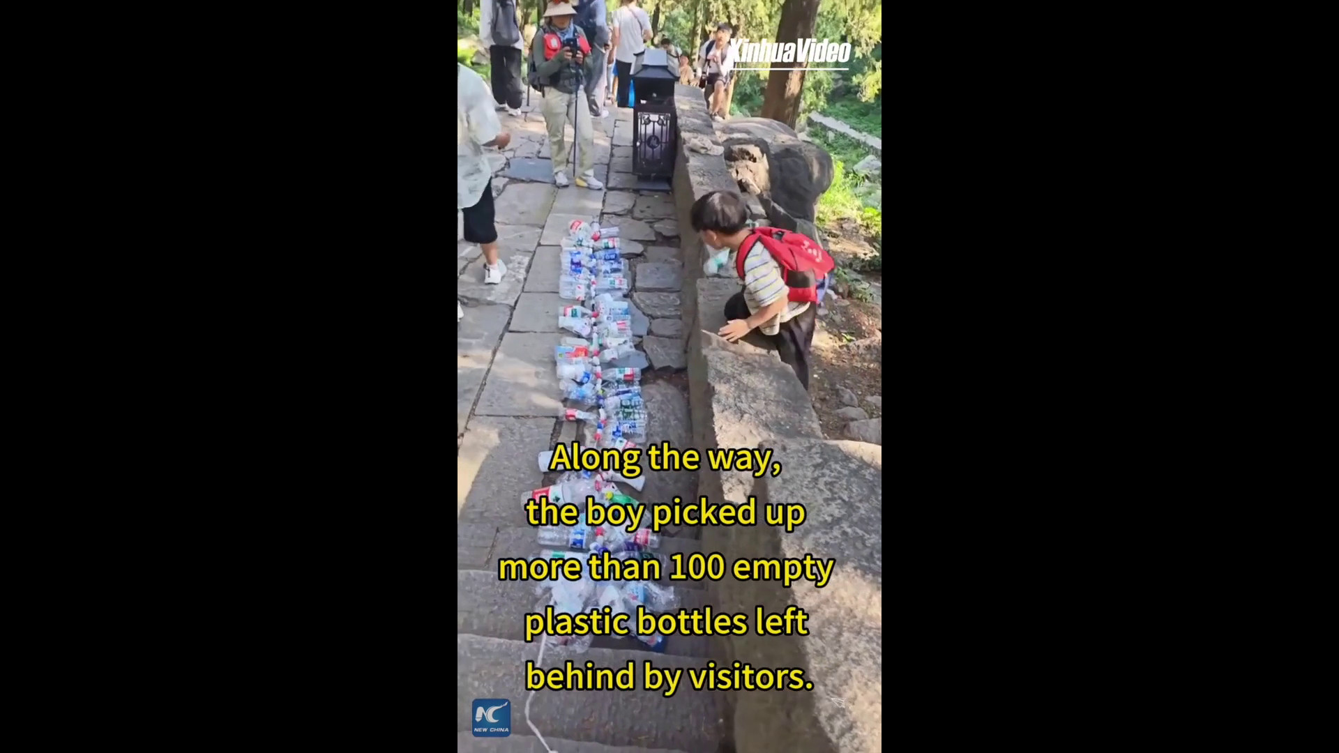 Ragazzo durante la scalata del monte Tai circondato da bottiglie di plastica raccolte